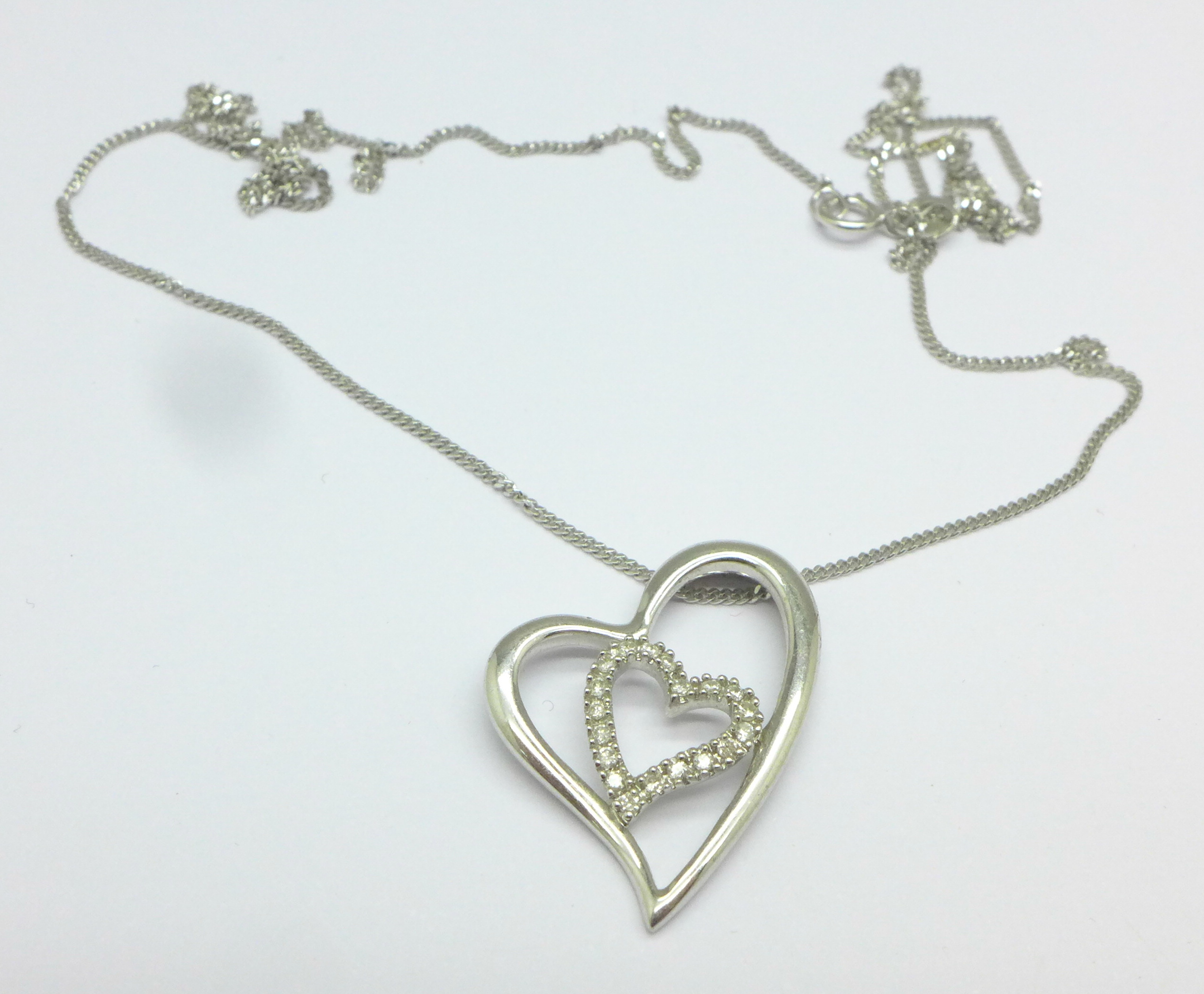 A 9ct white gold and diamond pendant and a 9ct white gold chain,