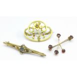 Two 9ct gold brooches including one set with garnets and one other brooch decorated with a flower