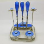 A silver and guilloche enamel manicure set on a glass base, Birmingham 1902, some enamel a/f,