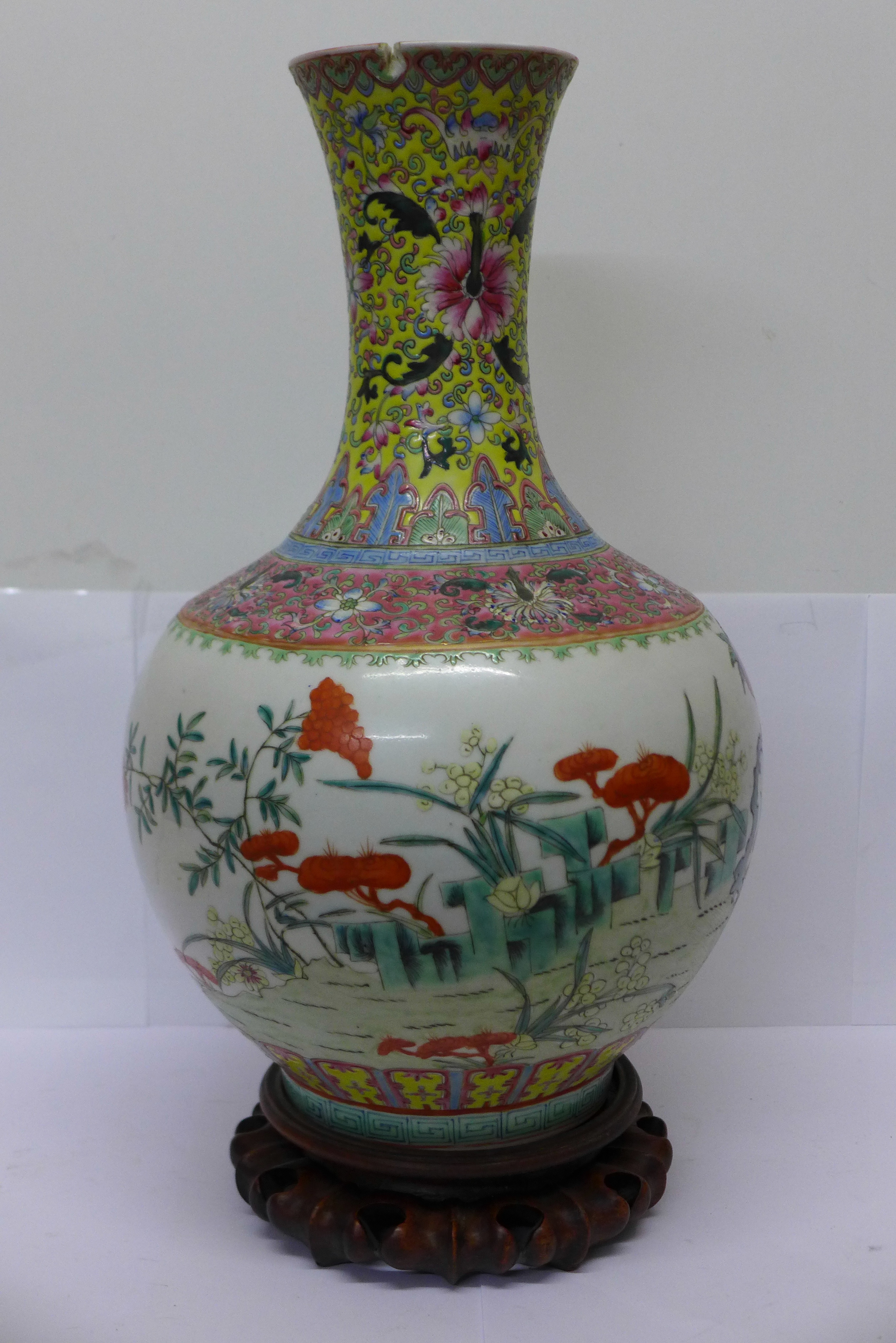 A Chinese famille verte vase on carved stand, six character mark on the base,