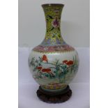 A Chinese famille verte vase on carved stand, six character mark on the base,