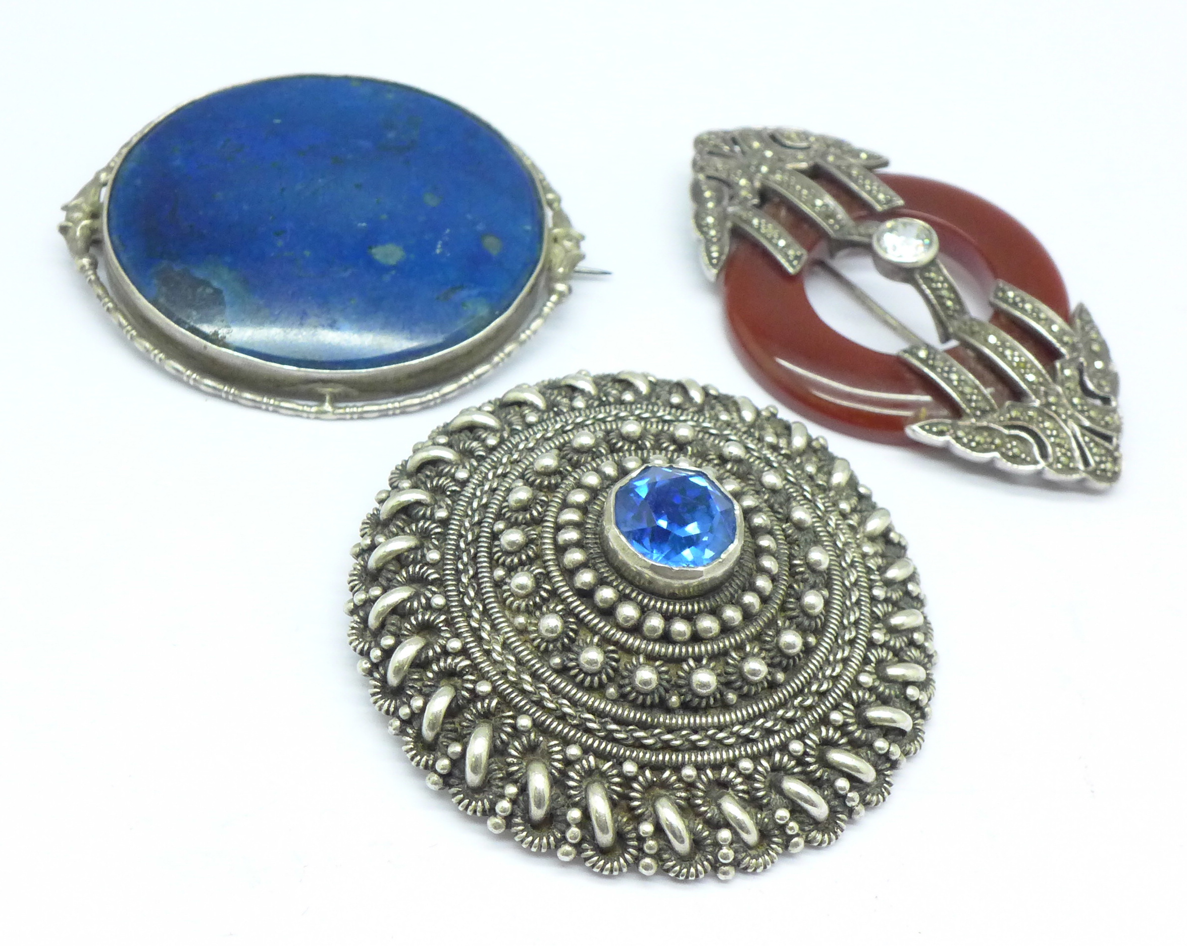 Three large silver mounted brooches
