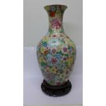 A Chinese floral pattern vase on carved wood stand,