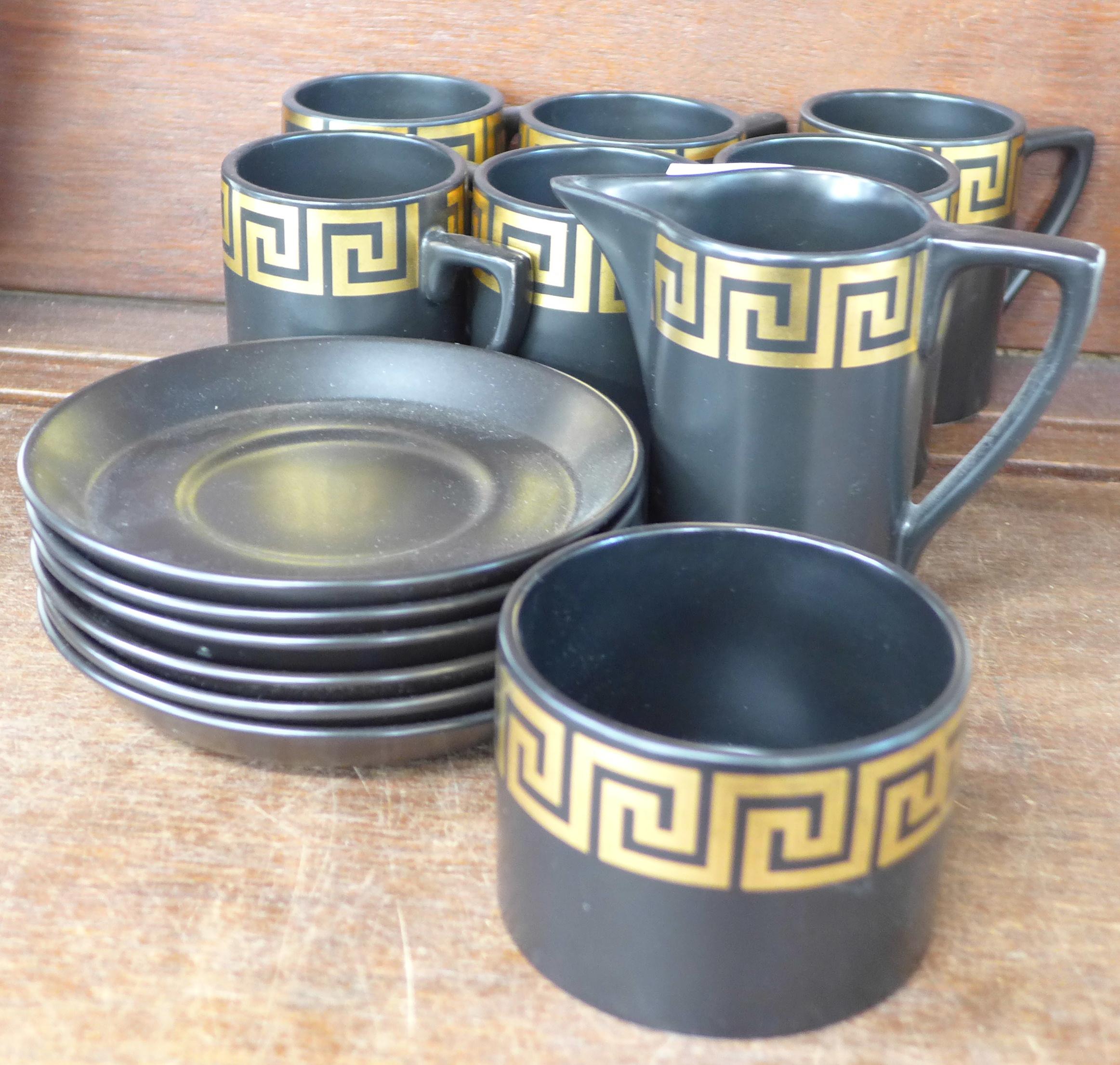 Six Portmeirion coffee cups and saucers and a cream and sugar bowl