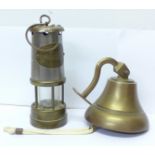 A miner's lamp and a wall mounted brass bell