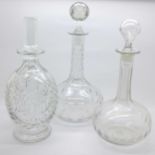 A crystal decanter and two other glass decanters