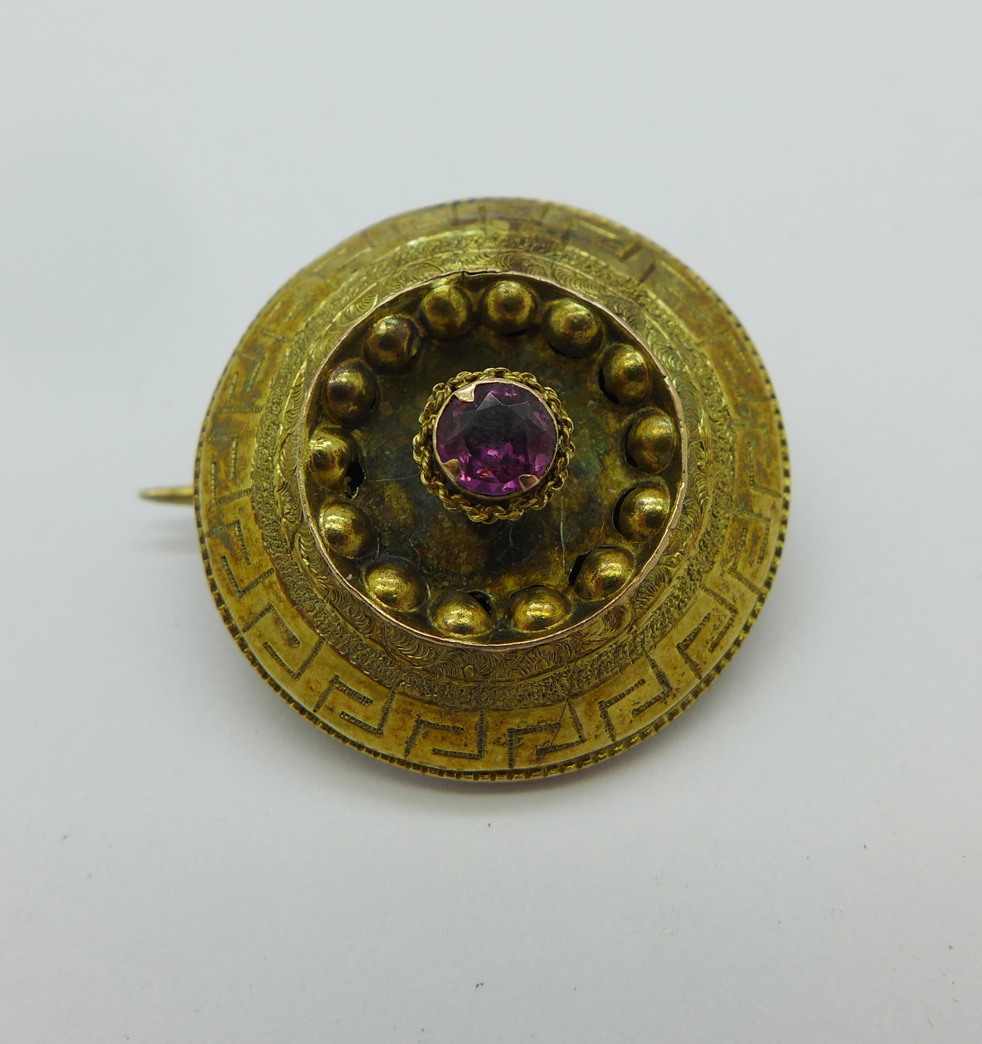 A Victorian brooch set with a pink stone