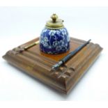An oak ink stand with blue and white inkwell