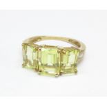 A 9ct gold and yellow stone ring with diamond set shoulders,