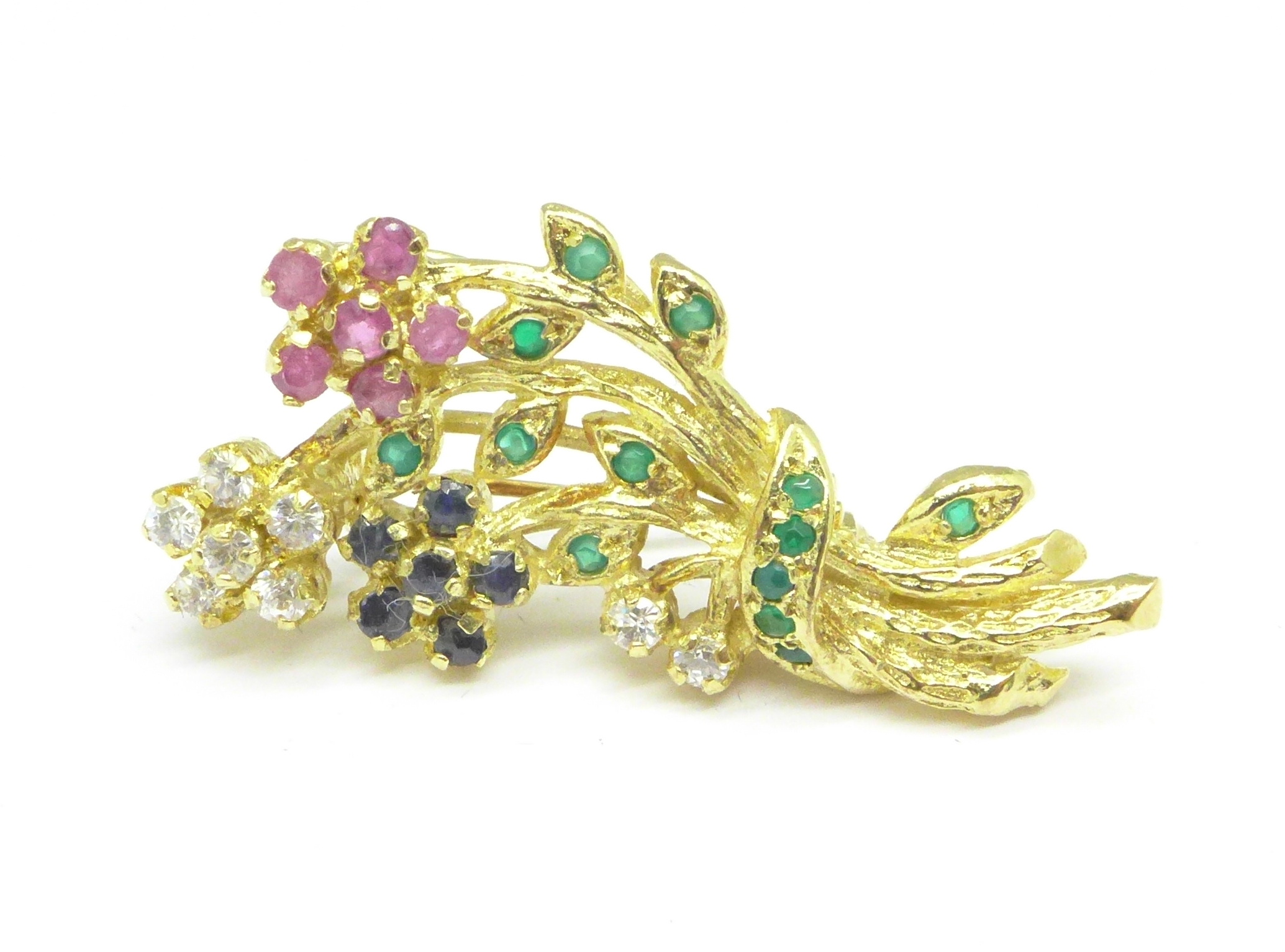 A silver gilt brooch set with rubies, emeralds,