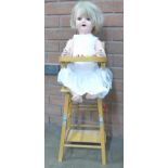 A doll's wooden high chair with old doll,