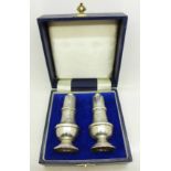 A pair of cased silver salt and pepper pots,
