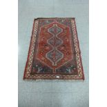 A Persian Shiraz red ground rug - 99cm x 150cm