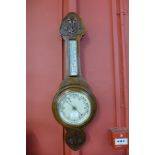 An Edward VII carved oak aneroid barometer