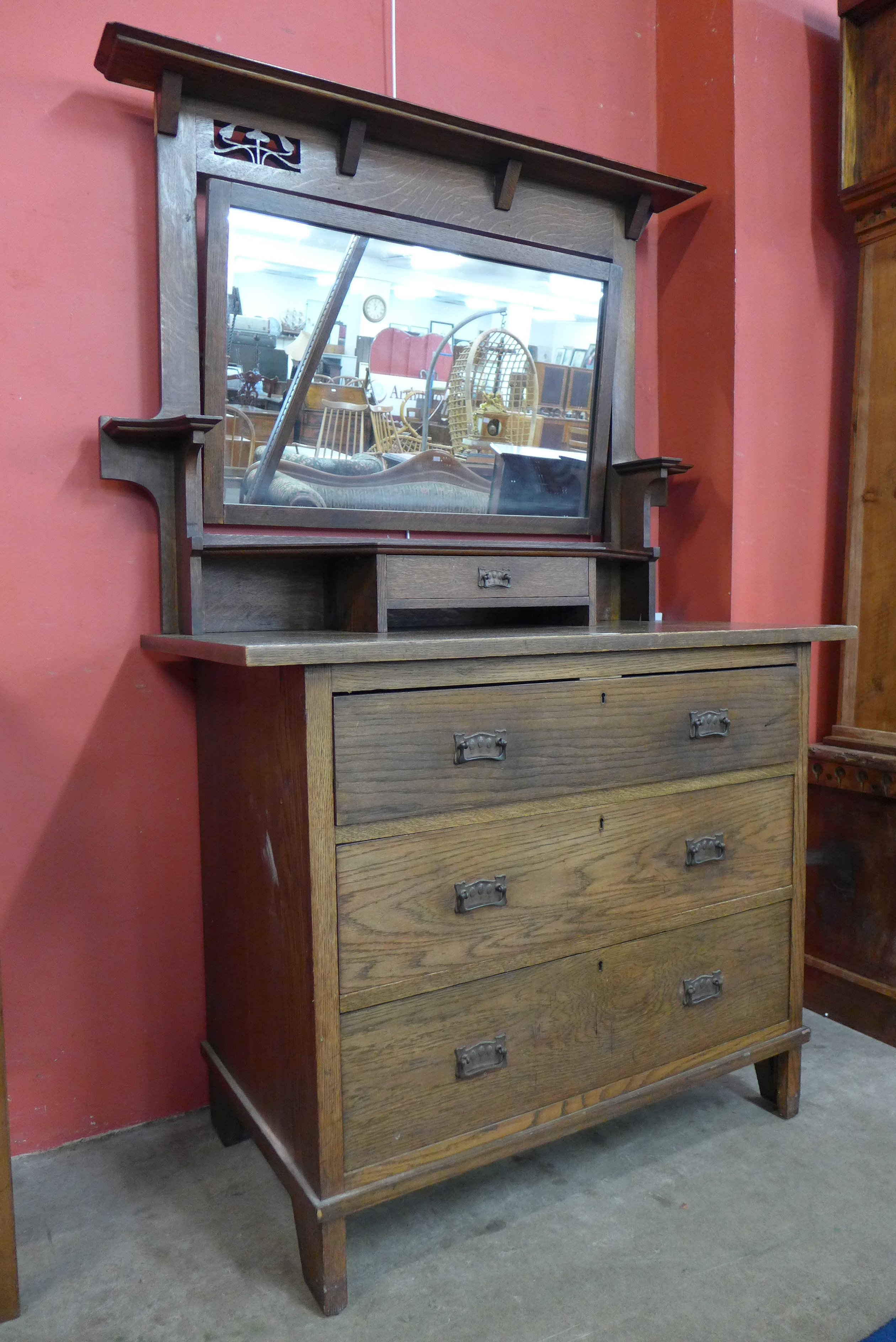 An Arts and Crafts oak dressing chest by Harris Lebus