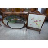 An Edward VII walnut fire screen and two oval mirrors