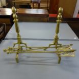 A pair of brass andirons and companion set