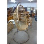 A 1960's wicker hanging chair on stand