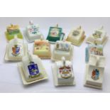 A collection of crested china cheese dishes including coloured,