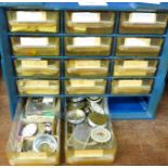 A cabinet of watch parts, stems, staffs, jewel end stones, etc.
