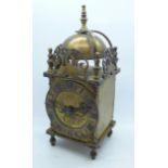 A brass lantern clock, marked W.H.