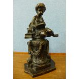 A French style bronze figure of a boy sat on a pedestal