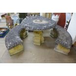 A cast concrete garden table and two benches