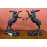 A pair of small bronze figures of boxing hares,