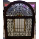 A large Arts and Crafts arched stained glass window,