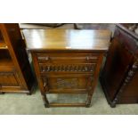 A carved oak credence cupboard