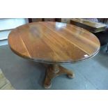 A solid walnut pedestal dining table by J.D. & M.