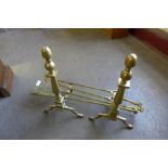 A pair of brass andirons and companion set