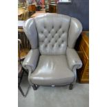 A mahogany and mauve leather wingback armchair