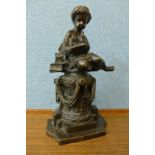 A French style bronze figure of a boy sat on a pedestal