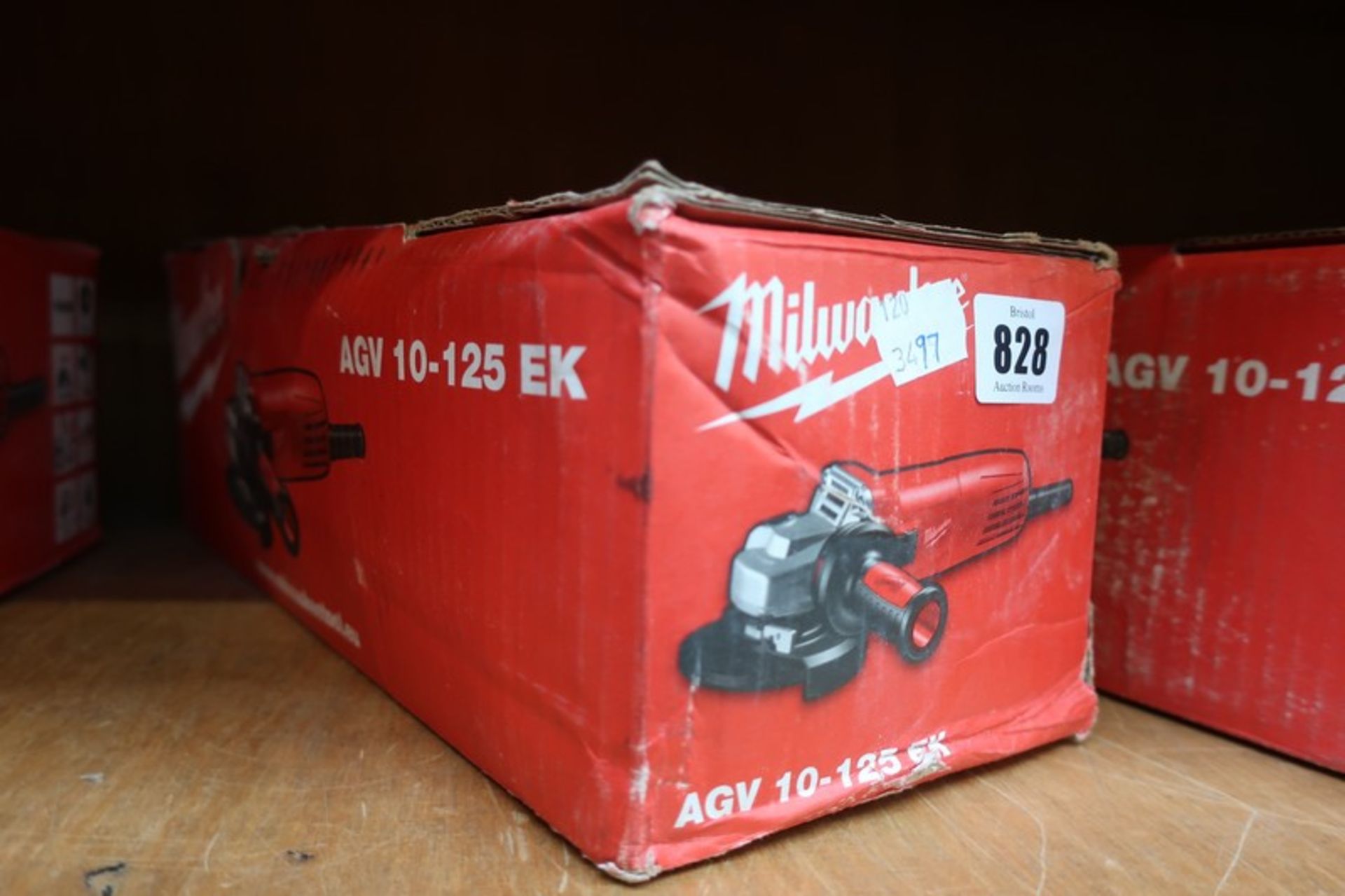 A boxed Milwaukee AGV 10-125EK 1000W angle grinder.