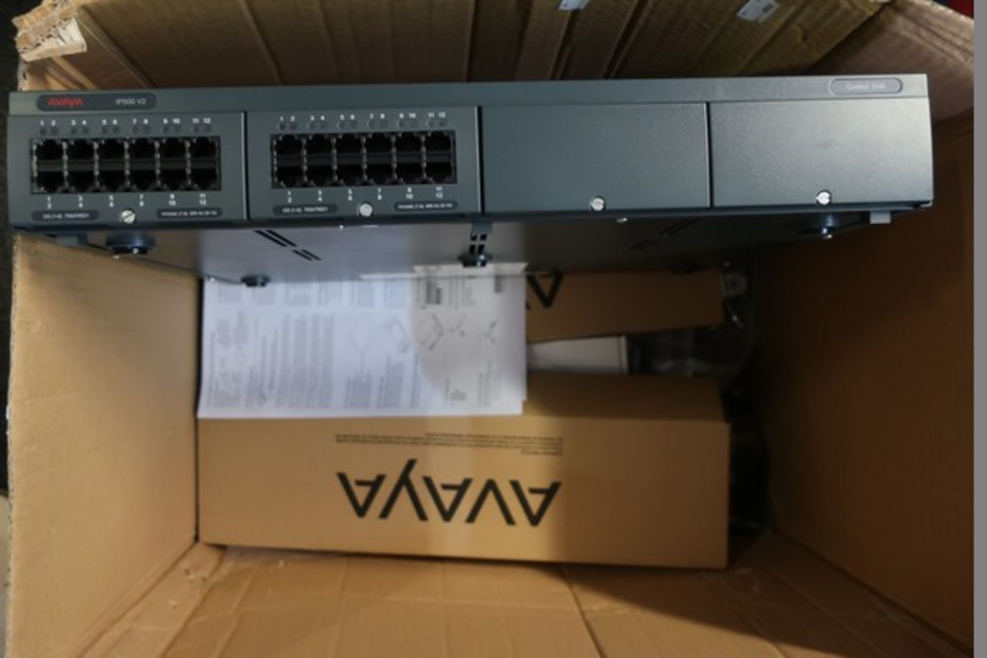 An AVAYA IP500 V2 control unit and other relevant items.