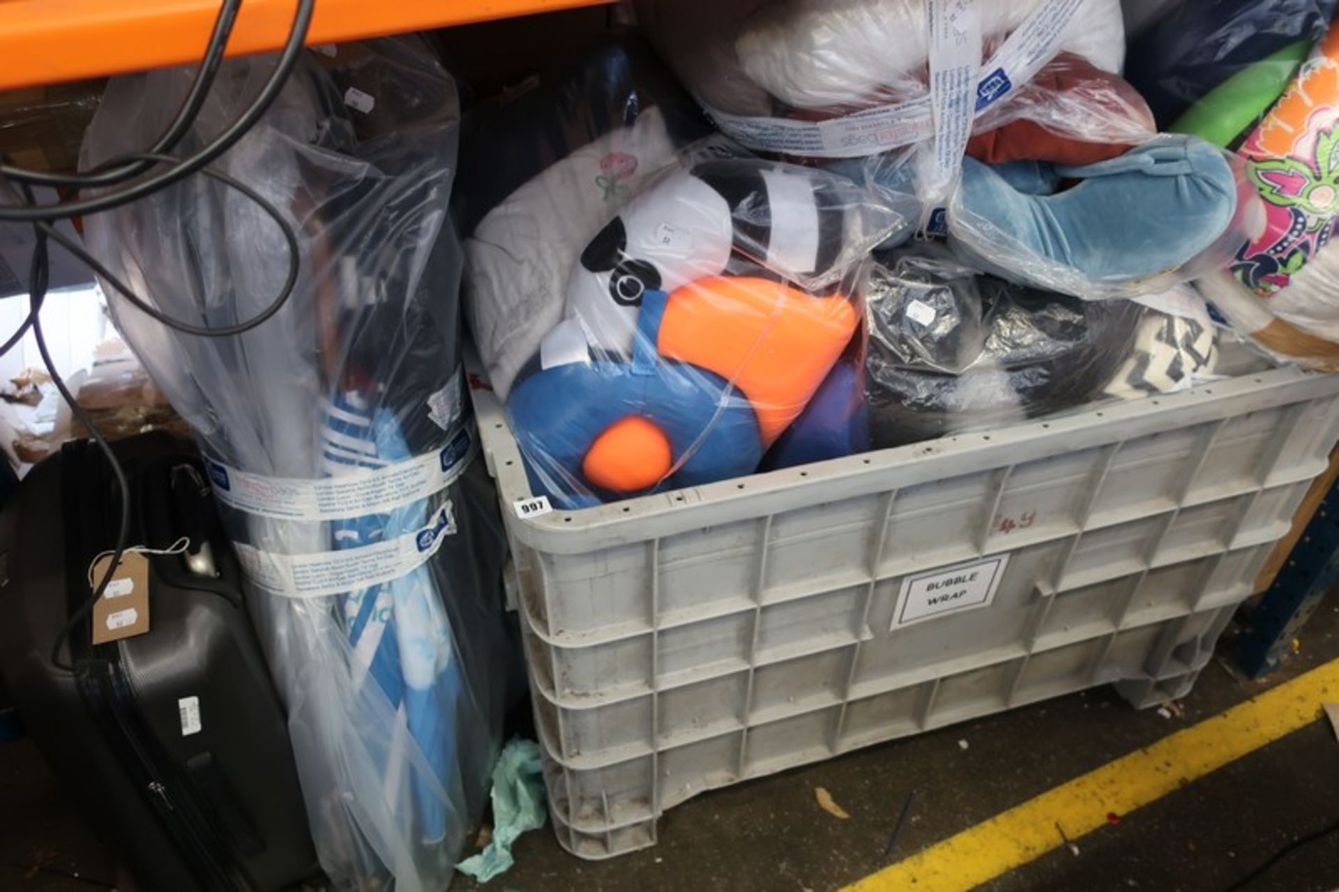 A crate of assorted neck pillows, a bag of walking umbrellas and a suitcase of handbag umbrellas (