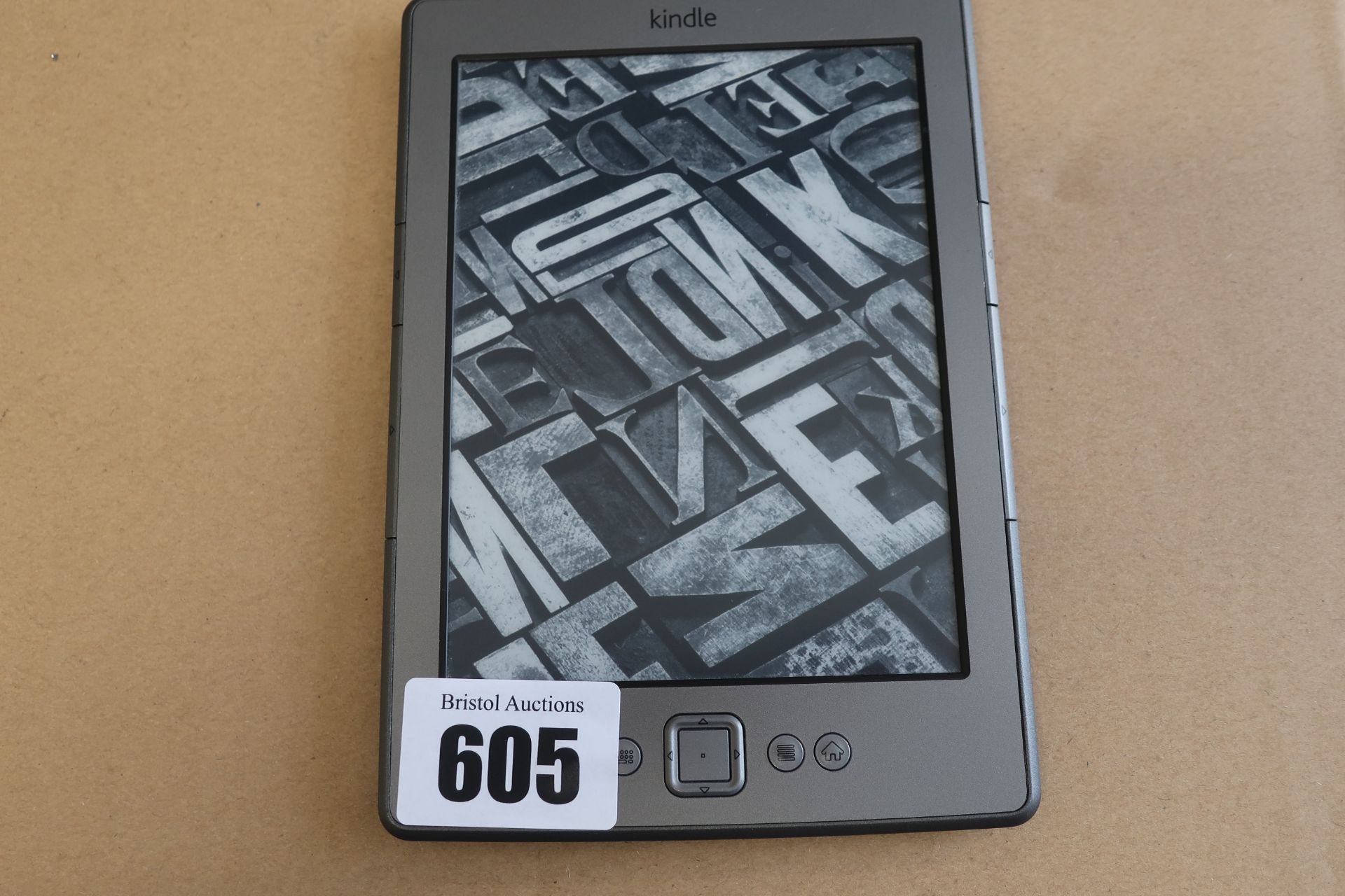 A pre-owned Amazon Kindle (D01100) 6” E-Reader in Grey.