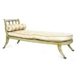 A Regency green painted and bamboo day bed, with scrolling back on swept supports and castors,