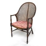 A caned open armchair with swept arms/back, turned supports and H stretcher