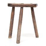 An early 19th century elm three legged milking stool