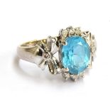 A 9ct gold white gold dress ring set with a blue stone and small diamonds, gross weight 2.9g, size K