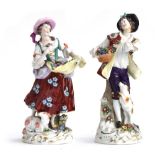 Two ceramic figures: a shepherdess with flowers and lamb, and boy with flowers and dog, the latter