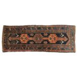 A tribal runner rug, indigo ground, three joined medallions, each depicting houses in gardens,