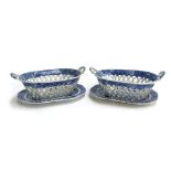 A pair of English blue and white china pierced chestnut baskets of oblong form with twin scroll