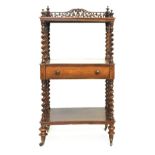 A Victorian rosewood three tiered whatnot with barley twist supports and turned finials, the top