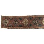 A narrow runner rug, joined central lozenges surrounded by a geometric border, 71x336cm
