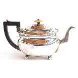 A George III silver teapot of oblong form with ebony harp handle, the half gadrooned body below a