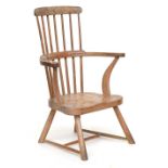 A West Country oak and elm low Windsor chair, seven spindle back, the arms with carved swept