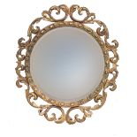 A circular giltwood wall mirror, the bevelled plate surrounded by bead moulding within an openwork